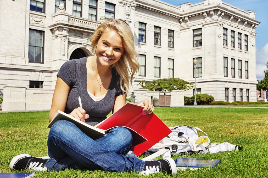 Student studying on college lawn